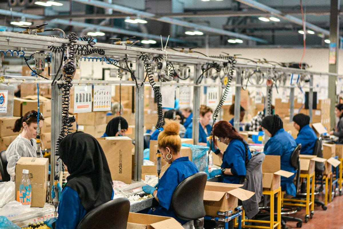 Operadores de uniforme azul em uma linha de montagem