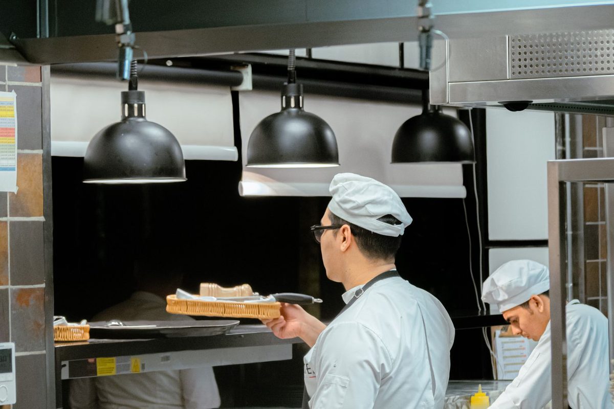 Cooks in hats and jackets on a kitchen line