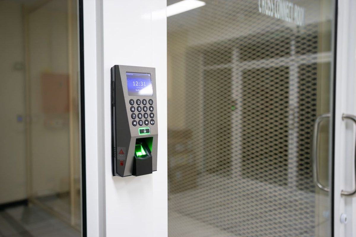 Biometric access terminal next to an office glass door